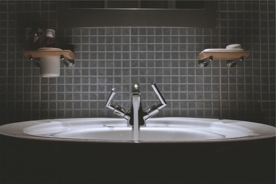 Bathroom basin and taps in a tiled bathroom